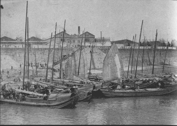 AT HANKOW—THE CHICAGO OF CHINA

River-front scene at low water, showing junks that transport general
cargo down-river from the exporting districts. This is a typical
riverfront scene.