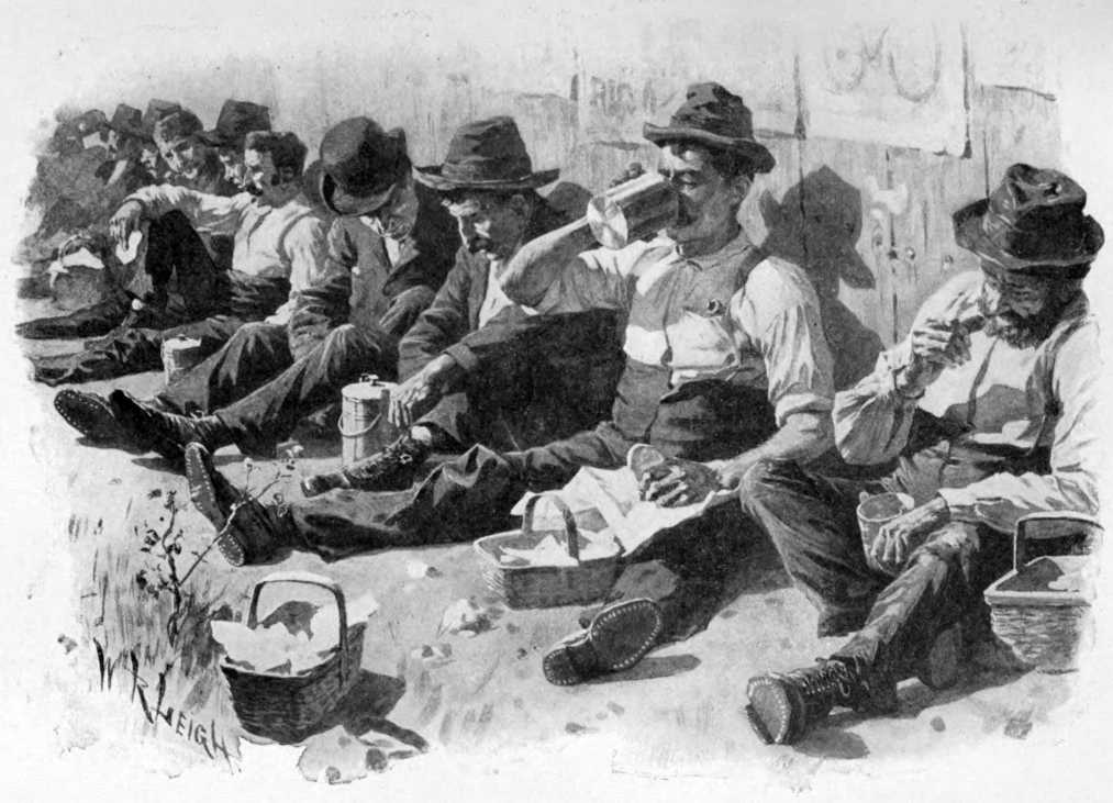 A long line of men sitting with their backs against a
wall having lunch.