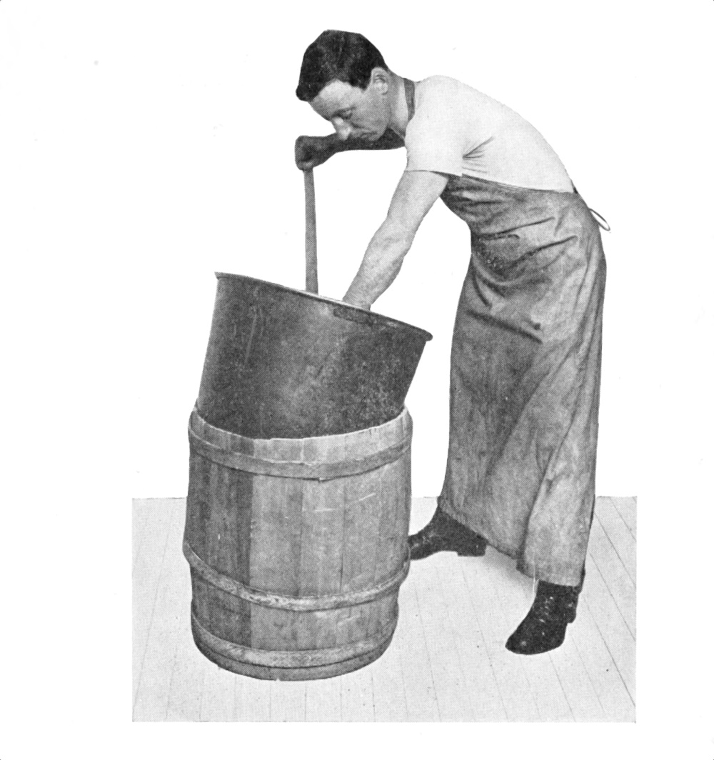 ‡Man stirring contents of a bucket
