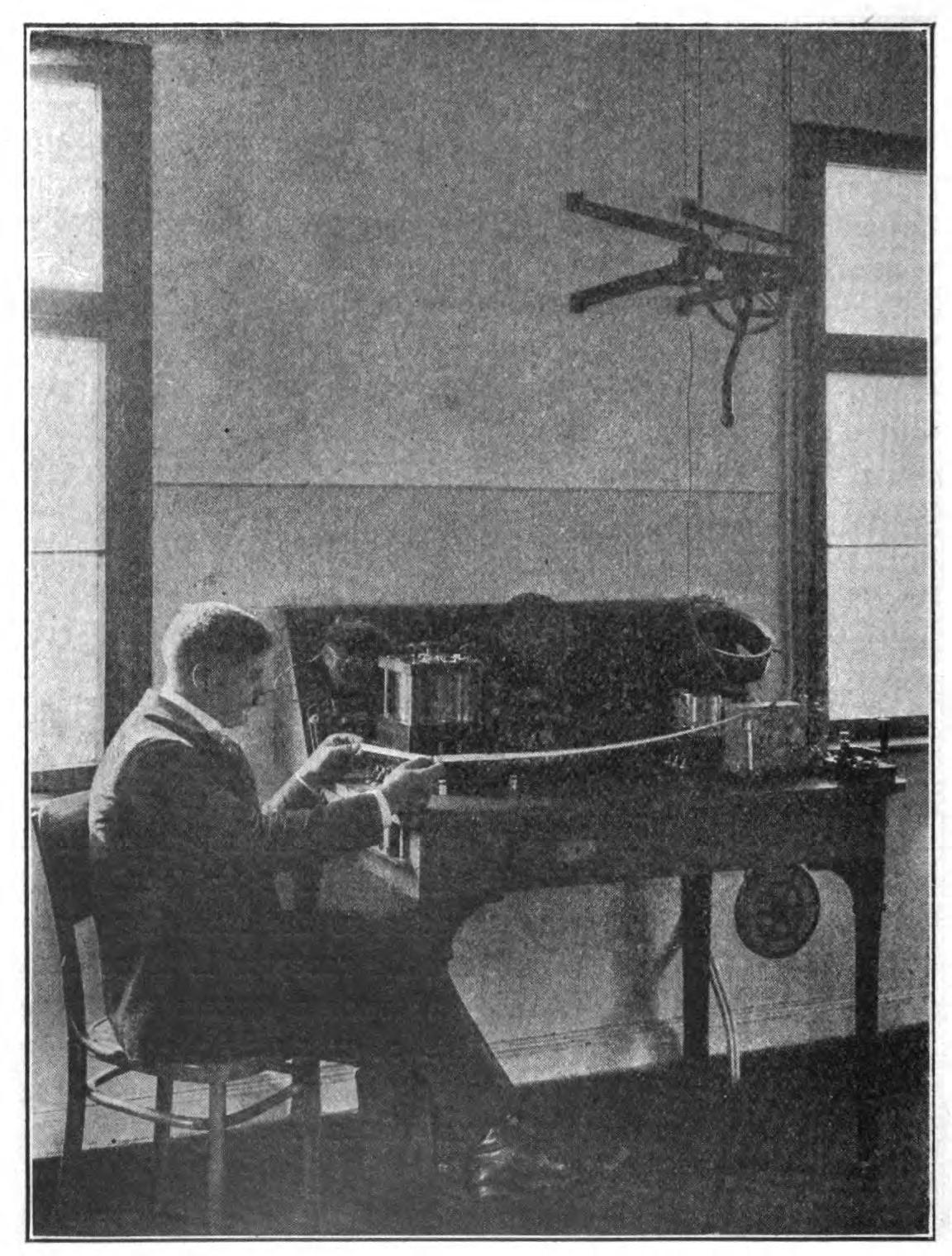 FIG. 119.—The receiving apparatus of the station at Nauen. The message is being printed on tape by a recording device.