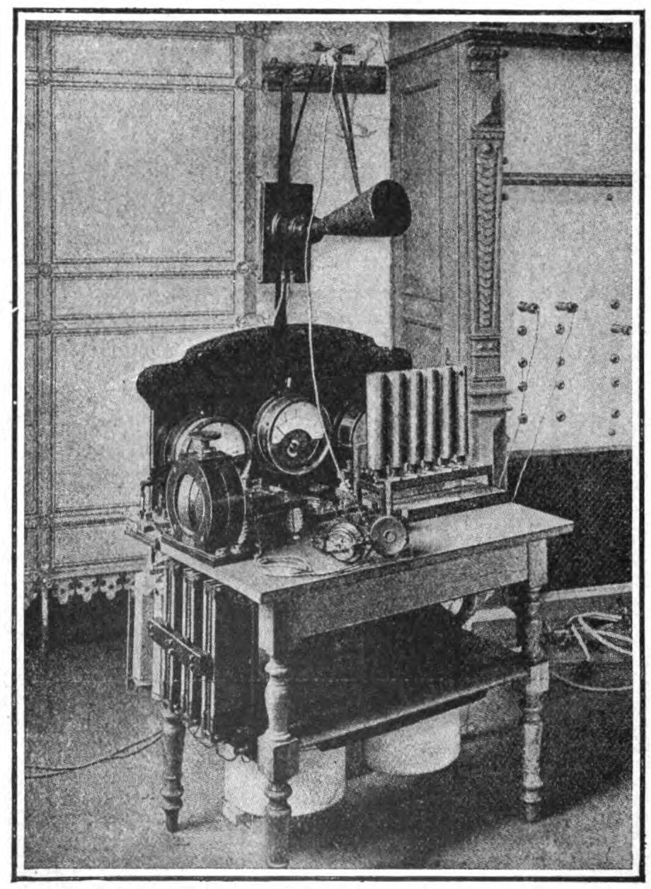 FIG. 147.—Poulsen wireless telephone equipment. The condenser shunted around the are usually consists of a number of metal plates, placed above one another in a tank of insulating oil. The inductance is simply a single helix or bare wire.